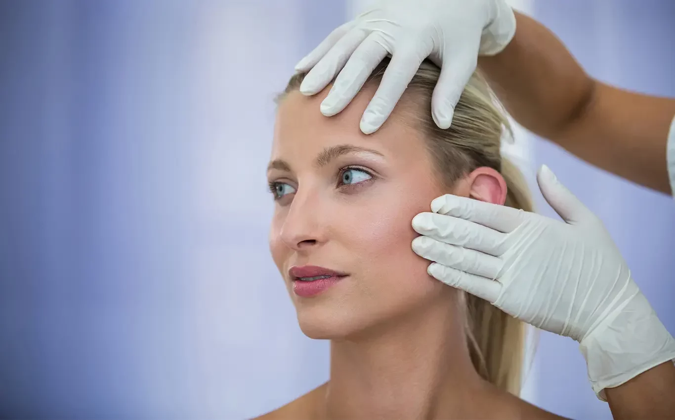 Demonstration of a cosmetic procedure with a female client and a doctor. The doctor's hand is visible, gently explaining the procedure while maintaining a hands-on approach, with the focus on the client's face.